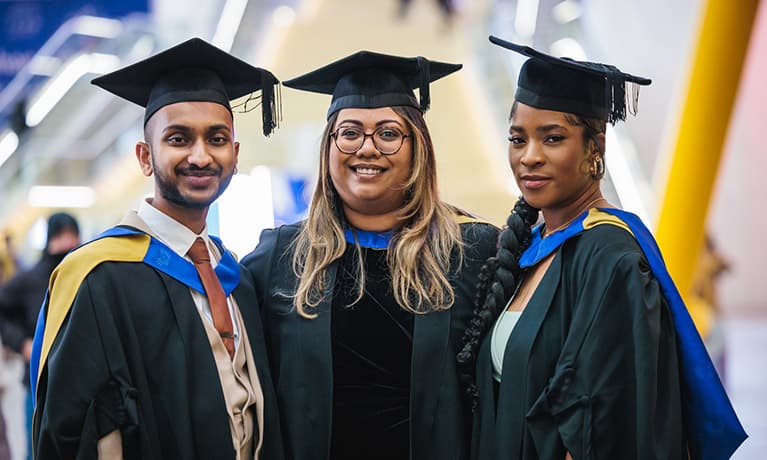Three graduates smiling in the o2 