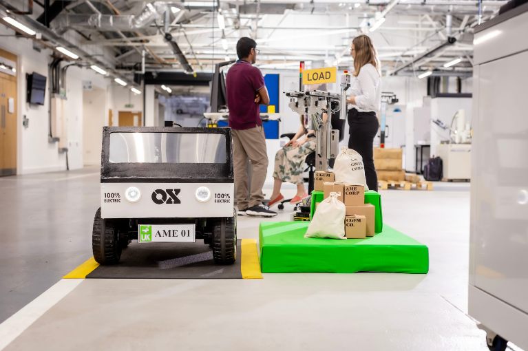 students in an engineering workshop infront of a prototype vehicle