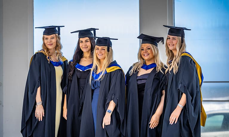 Group of female students in their graduation gowns and caps