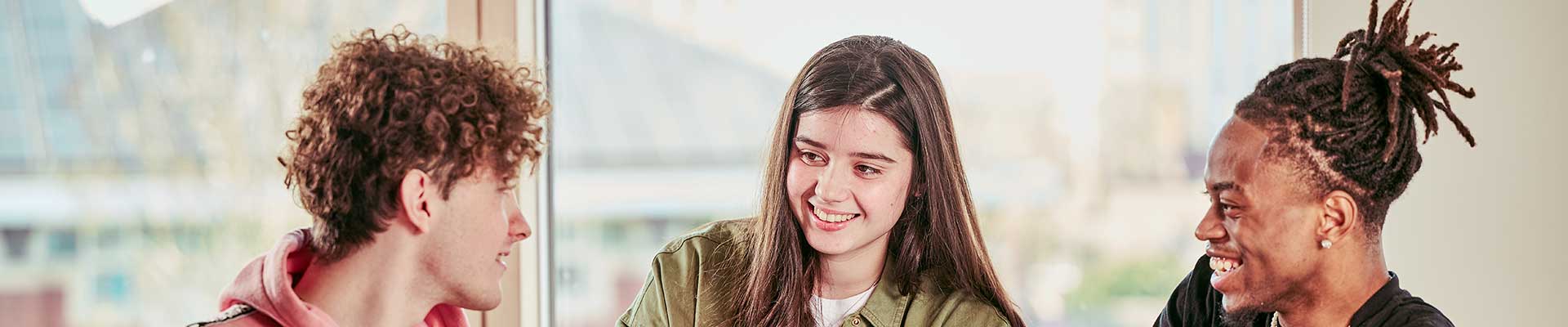 Three students sat at a table talking
