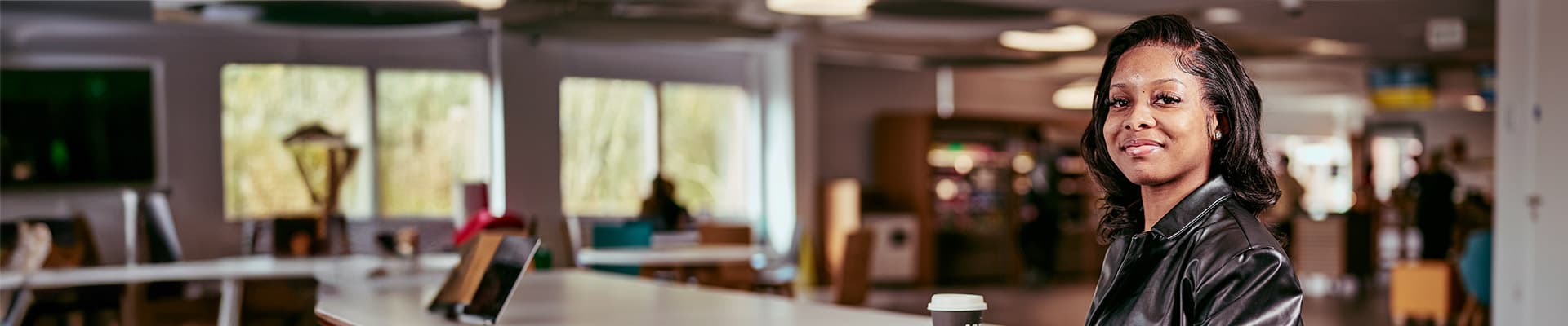Female student sat in an open space smiling