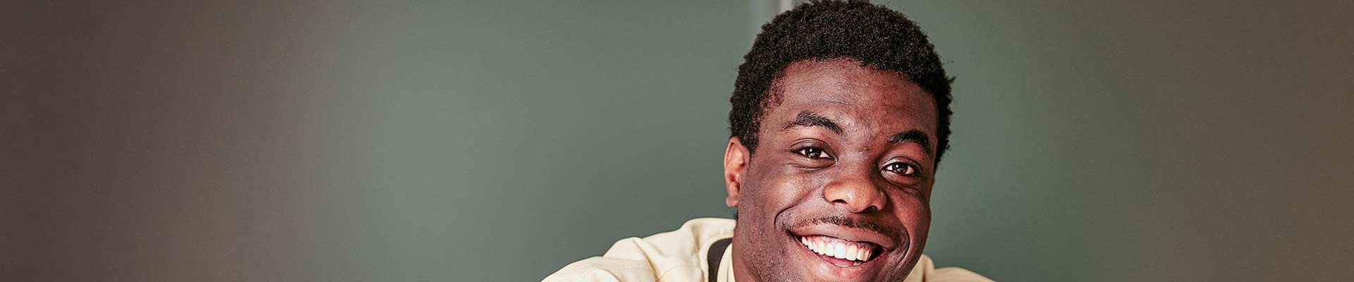 Student smiling in front of his laptop