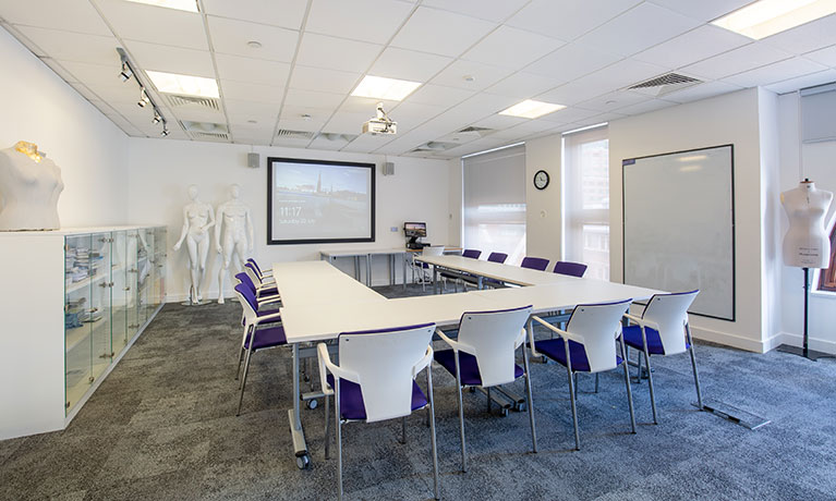 Fashion studio with tables and chairs and four mannequins 