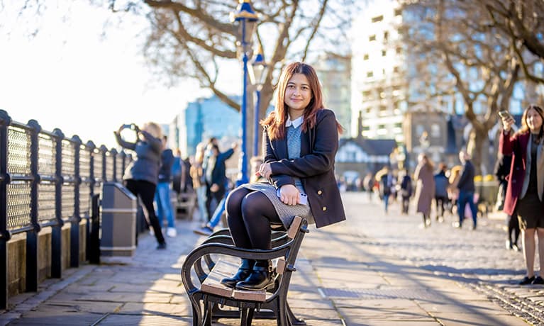 Female sat on a bench along the River Thames