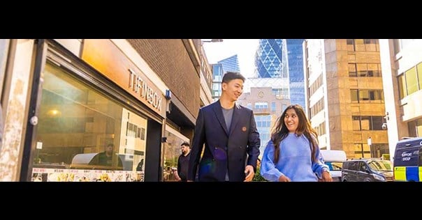 Male and female walking down a London street smiling 