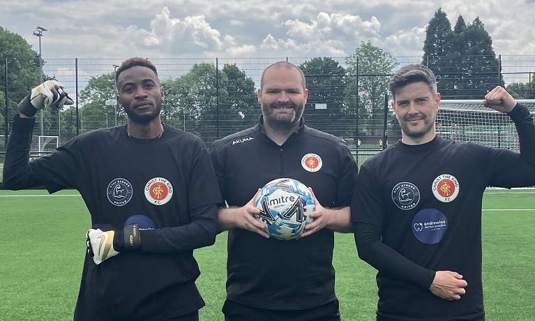 Sean Davies, founder of Stay Strong United, holding a football with fellow players Bright Omenogor and Jake Holcroft stood either side of him