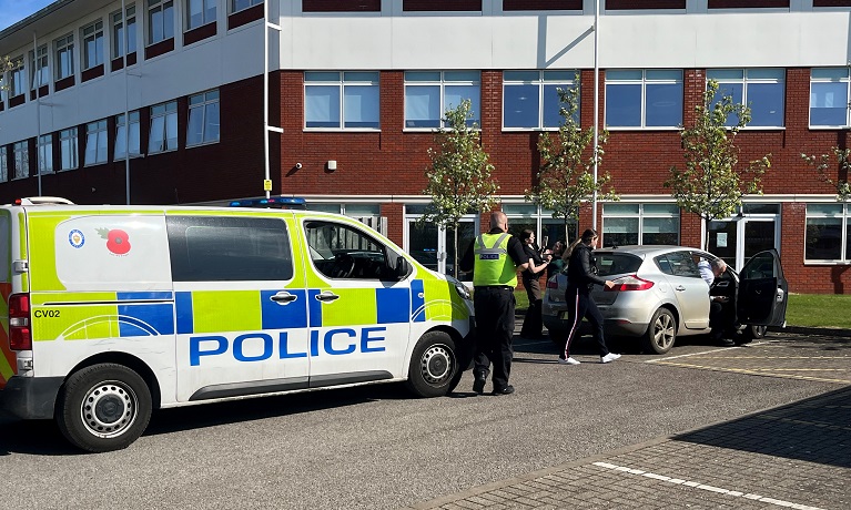 A police van behind  a car as CU Coventry students work with officers from West Midlands Police on a vehicle stop assignment