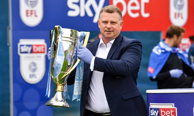 Mark Robins holding the League One trophy aloft