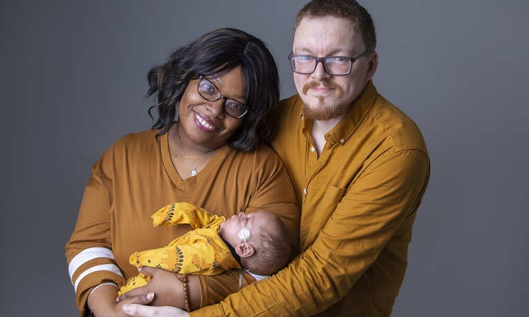 Maximus-Rex being held by his two parents