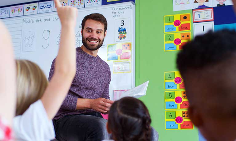 A male teacher in a class teaching