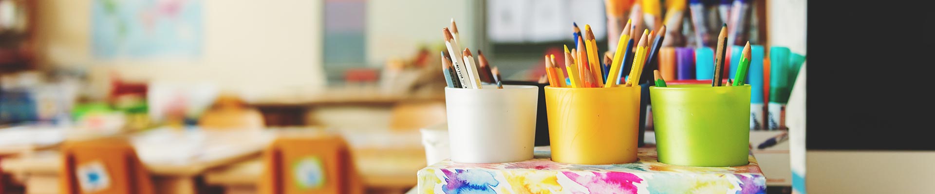 A classroom with paint brushes chairs and whiteboard