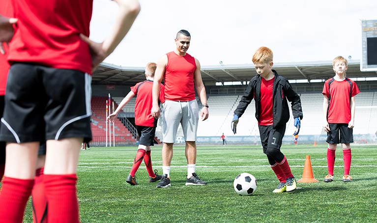 Children playing football on a pitch