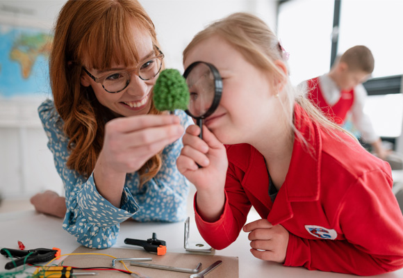 A teacher working with a young student with Down syndrome.