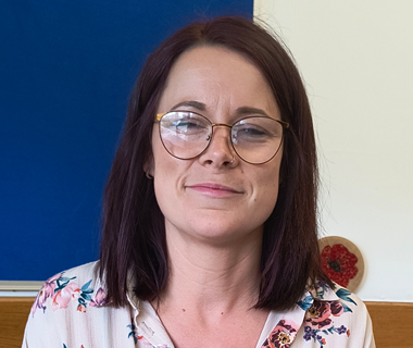 A portrait of Rebecca Chivers in a classroom.