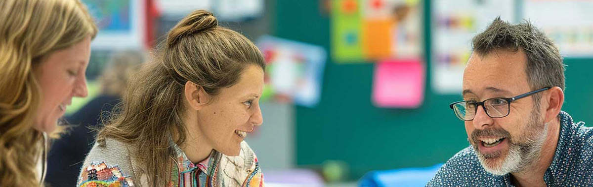 A group of teachers talking in a classroom.