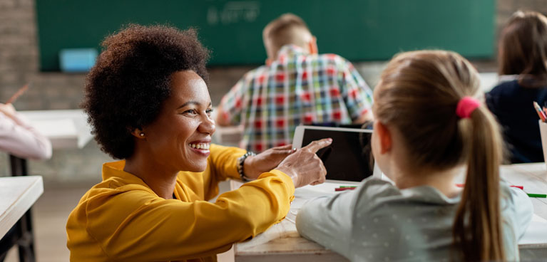 Teacher helping a pupil at a desk 