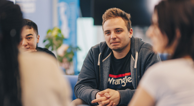 Students sitting in a circle talking.