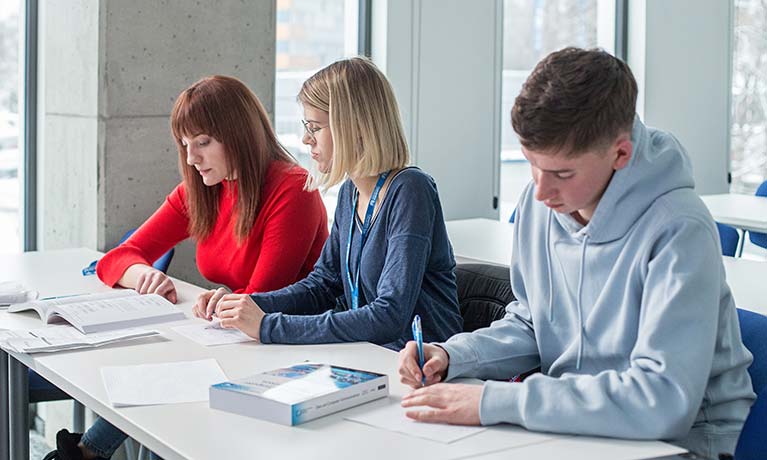 Students working at a desk in a study room