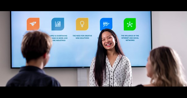 Woman presenting to students infront of digital whiteboard
