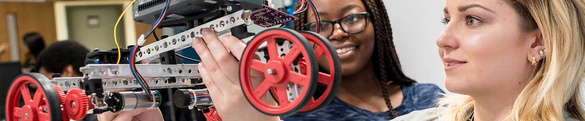two students looking at a project vehicle