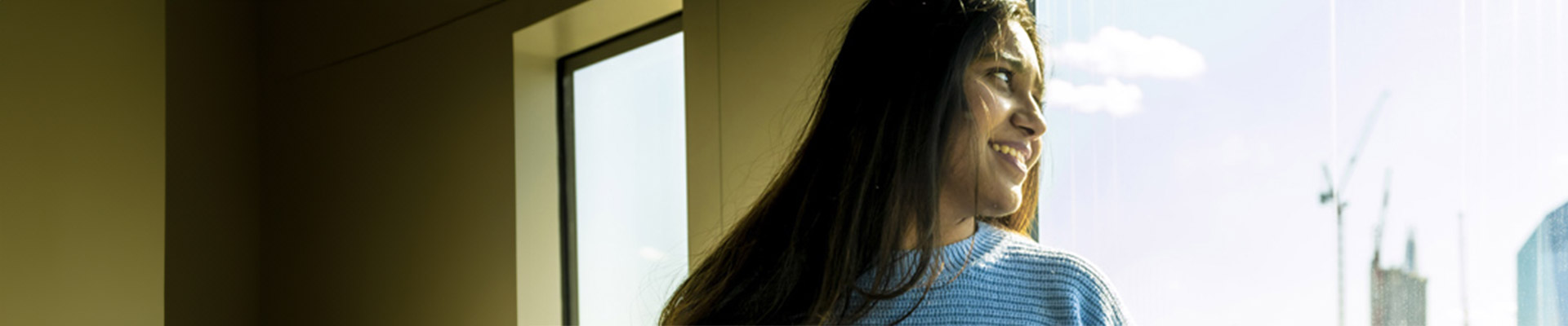 woman looking out of a window at the London skyline